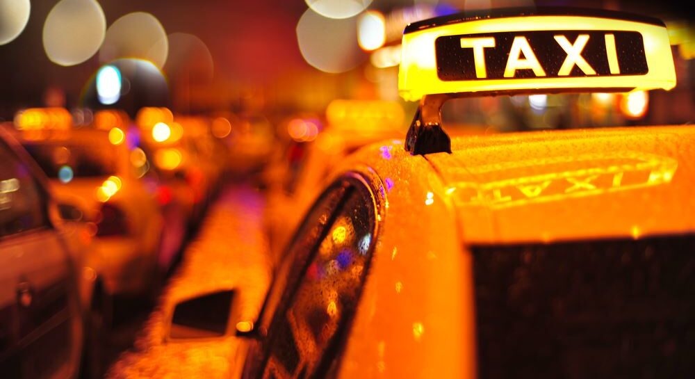 close up of lit taxi sign on top of cab