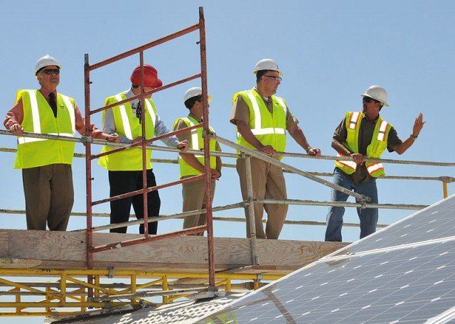 Construction Workers on scaffold leaning on safety railing