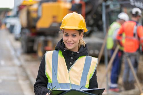 female construction worker in hard hat and reflective vest