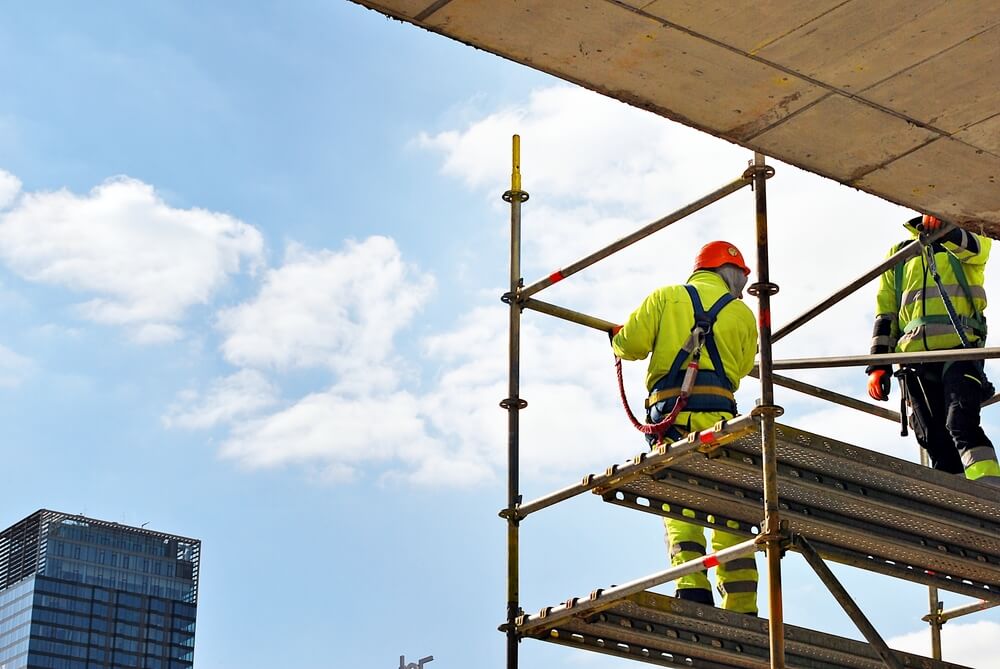 construction worker wearing harness on scaffold