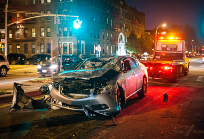 totaled car at New York intersection about to towed away at night