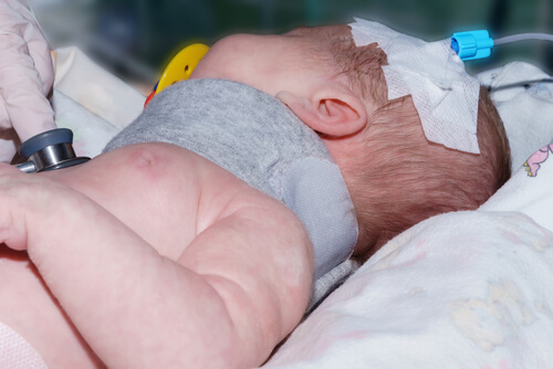 newborn baby with brace around neck and bandages on head