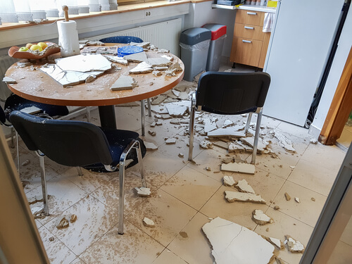 debris from ceiling collapse scattered over small table and chairs