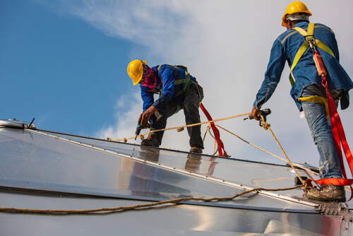 two roofers performing roof installation