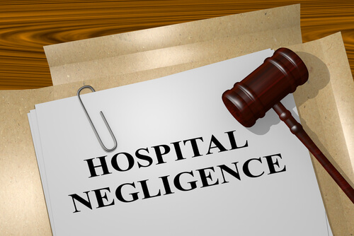 paperwork with 'HOSPITAL NEGLIGENCE' typed on it and judges gavel laid on top