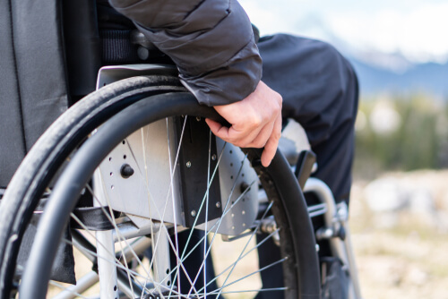 close-up of hands holding the tire of a wheelchair