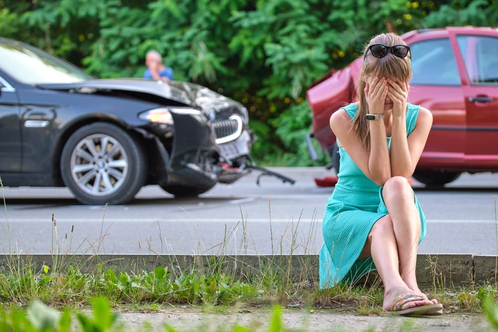 Sad female driver sitting on the street