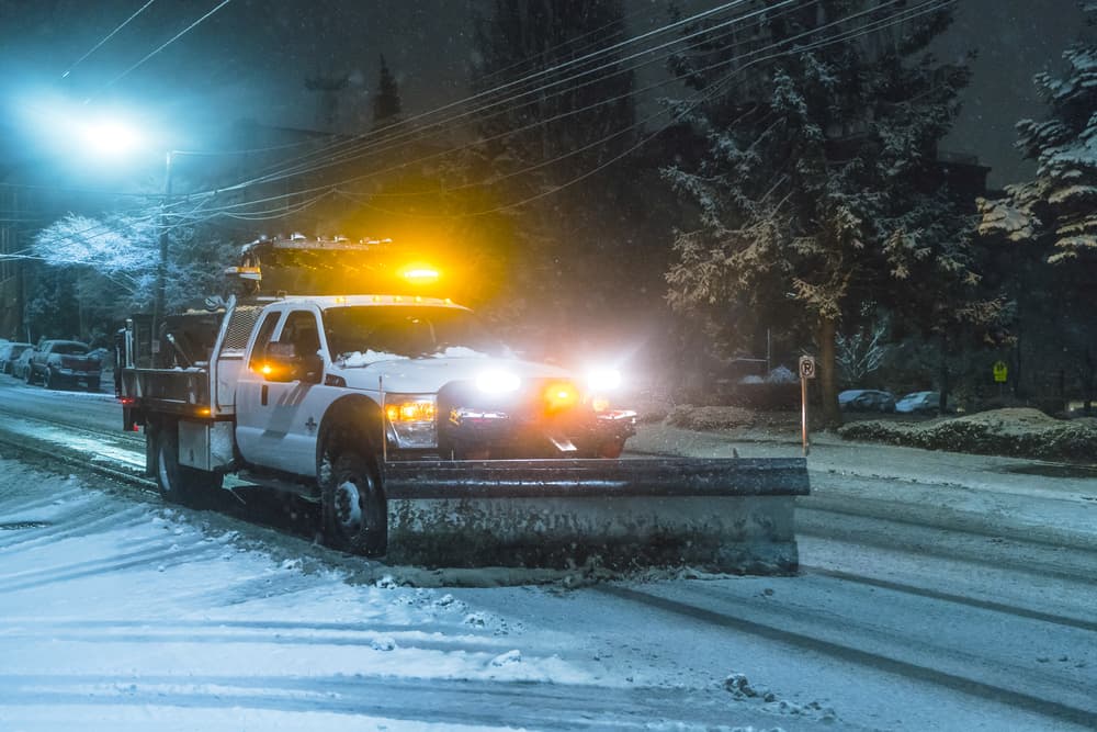 NYC snow plow driving streets at night