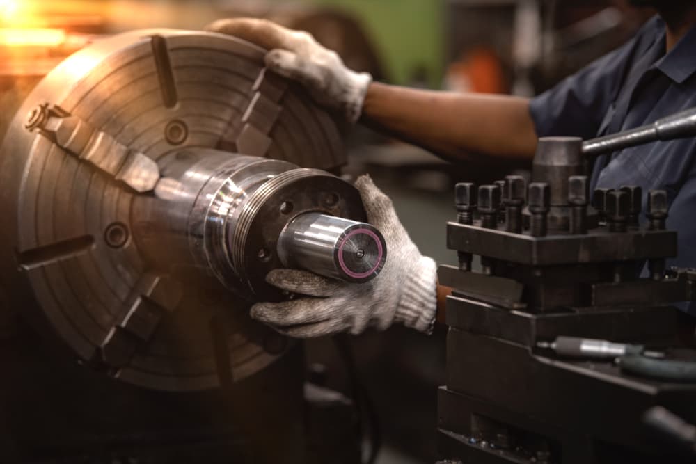 employee using a metal grinder machine wearing only gloves for protection