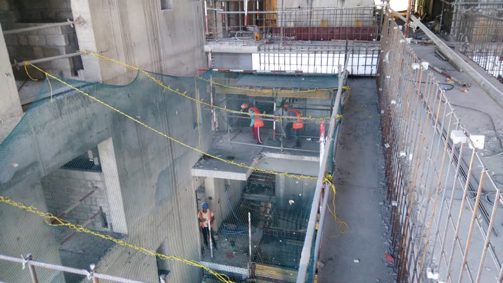 multi-floor construction site with safety nets between open levels to provide safety measures for NYC construction workers against falling objects