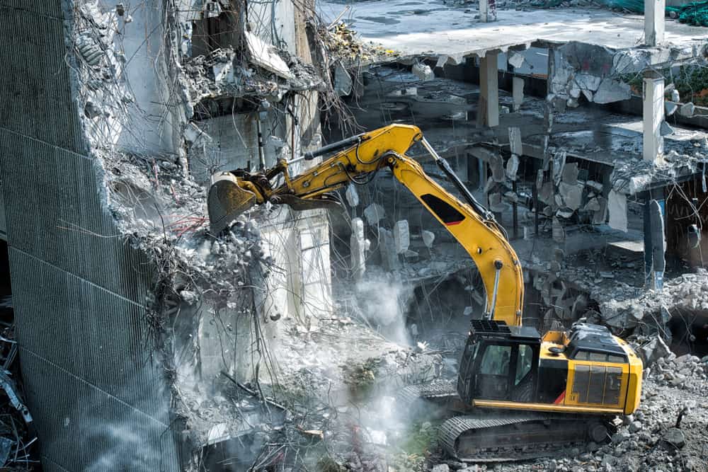 construction vehicle performing demolition work on a building