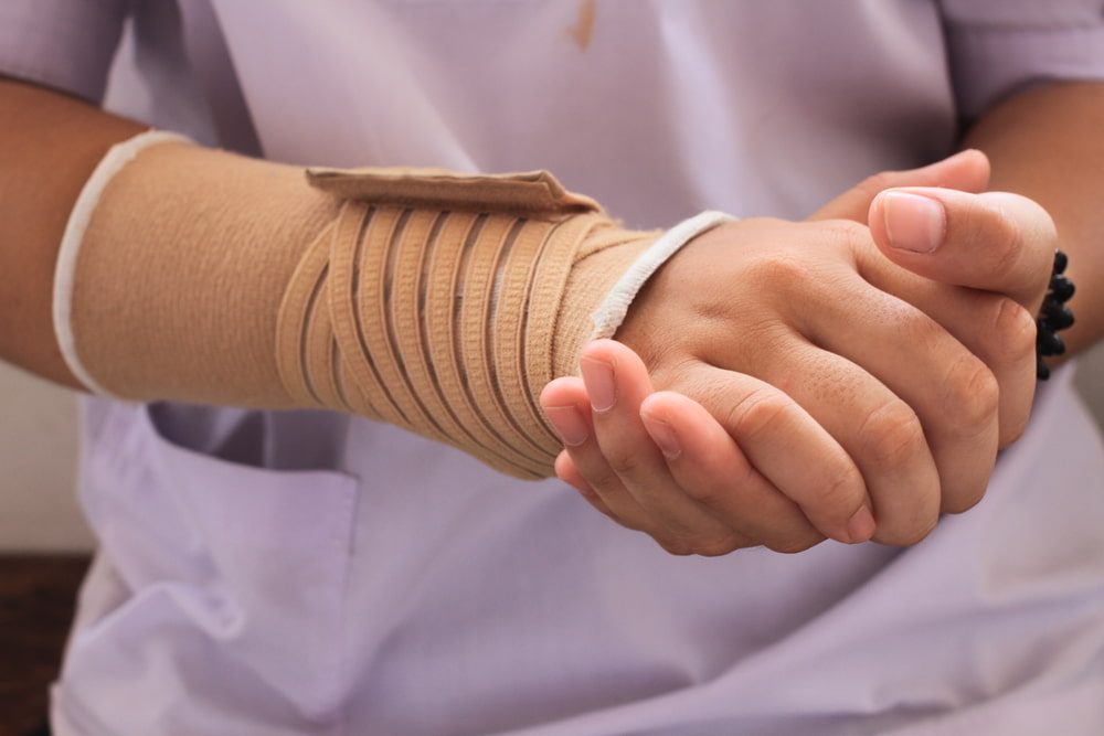 Nurse with wrist injury clasping her hands