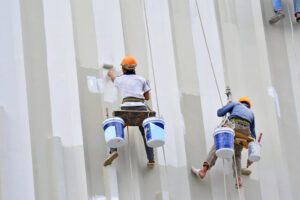 painters are hanging to paint with high building.