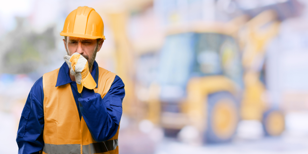construction worker coughing into hand