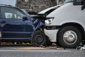 Two damaged cars after head-on collision on road.