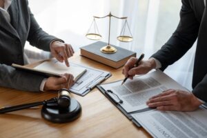 Lawyer and legal advisor reviewing business contracts and financial agreements in legal documents to ensure accuracy