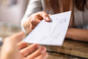 Person handing over a check for payment or legal settlement.