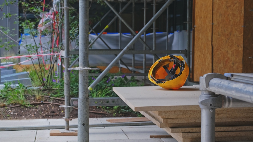 NYC scaffold accident lawyers image of construction site scaffold and safety helmet.
