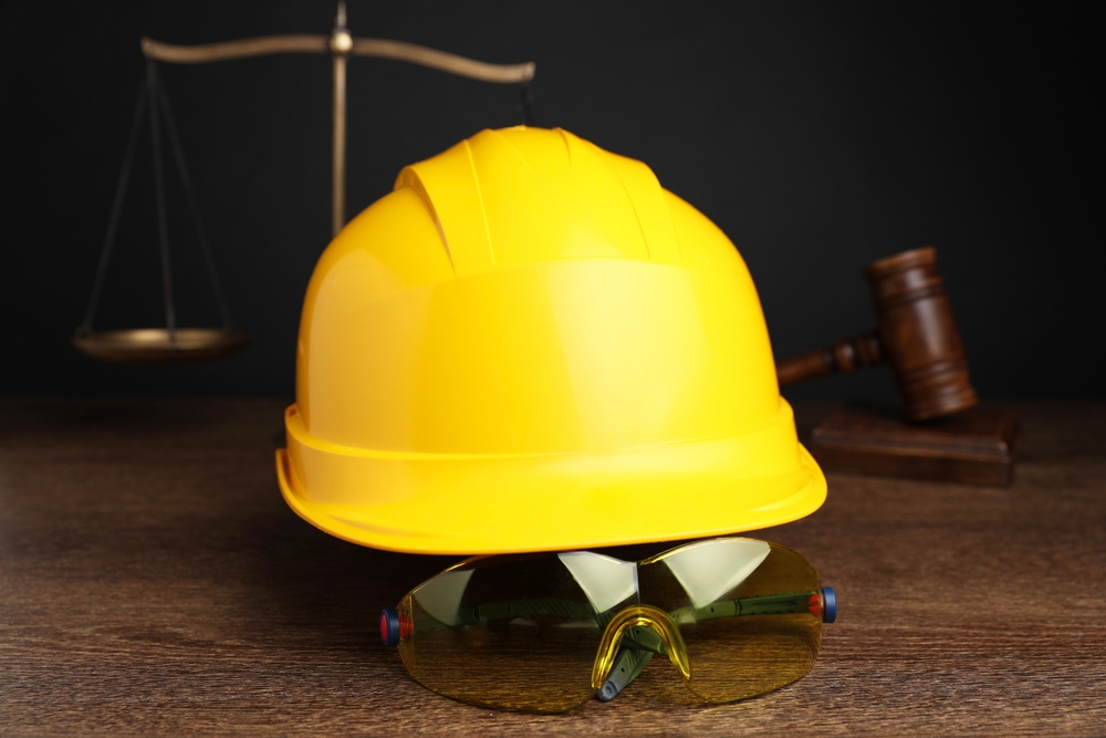 Manhattan construction accident attorney concept with hard hat, safety goggles, and gavel representing workplace injury law.